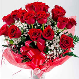 Bouquet of red roses with baby's breath in a clear glass vase