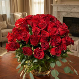 Red roses arranged in a glass vase on a table