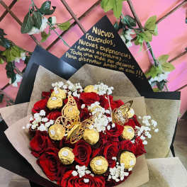 Bouquet of red roses with gold-wrapped chocolates and white baby's breath