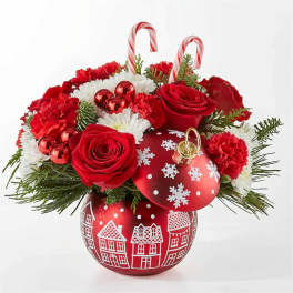 Red roses and white flowers in a red holiday ornament vase