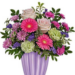 Mixed pink, purple, and cream flowers arranged in a lavender vase