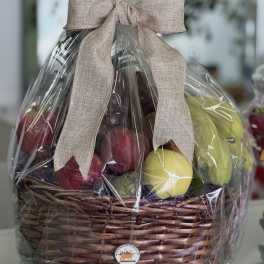 Wrapped fruit basket in a wicker container with a beige bow