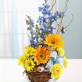 Basket arrangement with yellow and orange flowers and blue blooms