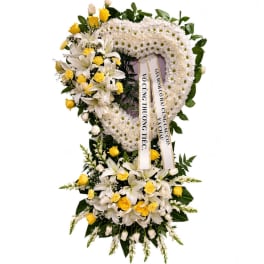 Heart-shaped funeral wreath with white flowers and yellow roses