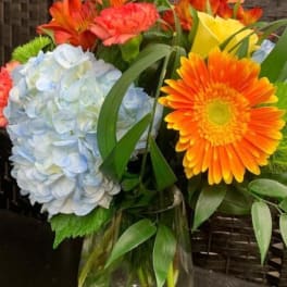 Bouquet with blue hydrangea, orange gerbera daisies, and yellow roses