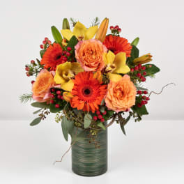 Orange and yellow mixed flower arrangement in a green vase