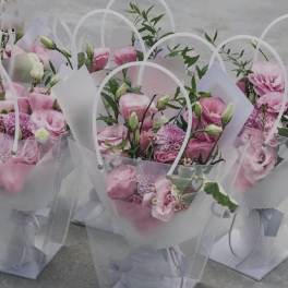 Pink flower bouquets in clear gift bags with white handles