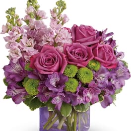 Purple roses and alstroemeria in a square glass vase