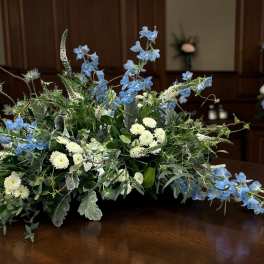 Low floral arrangement with blue and white flowers on a table