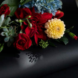 Gift card with a floral arrangement of red roses, blue hydrangea, and a yellow dahlia