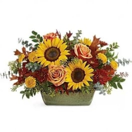Sunflower and rose arrangement in a green rectangular vase
