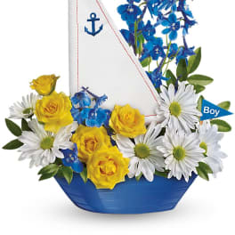 Blue and white sailboat arrangement with yellow roses and daisies