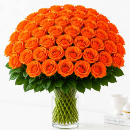 Large bouquet of orange roses in a clear glass vase