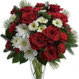 Red roses and white daisies in a clear glass vase