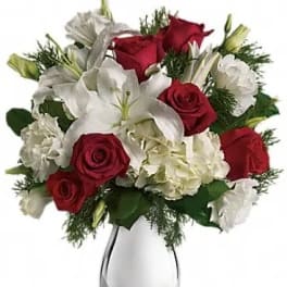Red roses and white lilies arranged in a clear glass vase