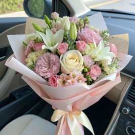 Pink and white mixed bouquet wrapped in pastel paper with a ribbon
