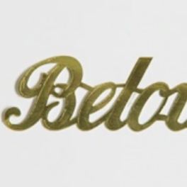Gold script sign reading "Beloved" on a white background