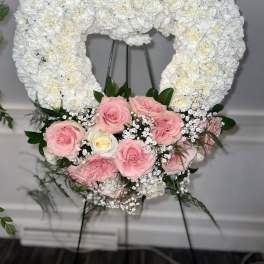 Heart-shaped white floral wreath with pink roses at the base