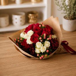 Bouquet of red and white roses wrapped in brown paper