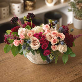 Mixed pink and cream roses in a low ceramic bowl