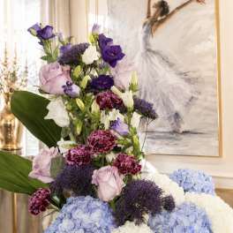 Tall floral arrangement with blue hydrangeas, purple lisianthus, and pink carnations