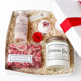 Gift box with bath salts, soap, candle, lip balm, and a red rose