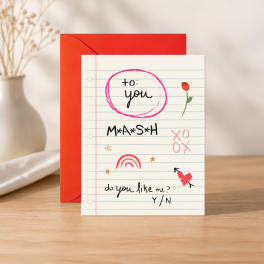 A greeting card with a red envelope on a table