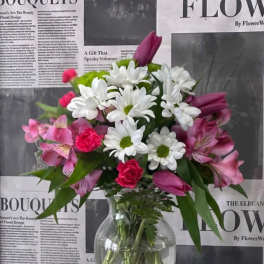 Bouquet of white daisies and pink flowers in a clear glass vase