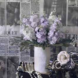 Lavender and white flowers arranged in a ribbed white vase