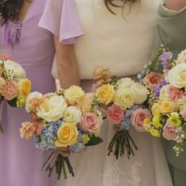 Bridesmaids holding pastel rose bouquets