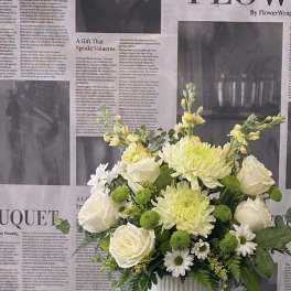 White roses and pale yellow chrysanthemums in a white vase