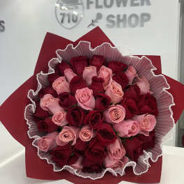 Bouquet of red and pink roses wrapped in red paper