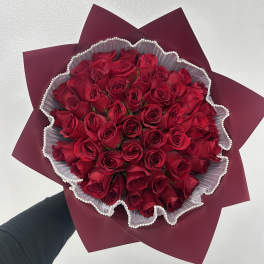 Bouquet of red roses wrapped in burgundy paper