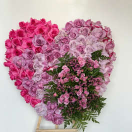 Heart-shaped pink and lavender rose arrangement on an easel