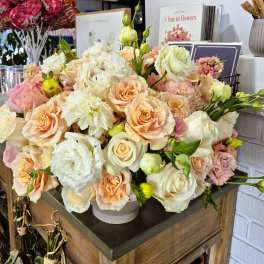 Large bouquet of peach, white, and pink roses with white lisianthus