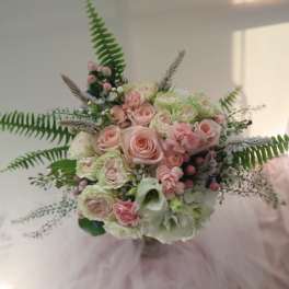 Bouquet of pale pink and white roses with greenery