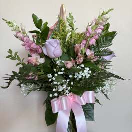 Pink and lavender bouquet in a glass vase with a pink ribbon