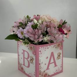 Pink and white bouquet in a decorated baby gift box with the letters B and A