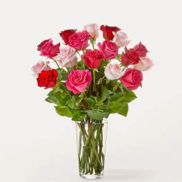 Bouquet of pink, red, and white roses in a clear glass vase