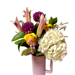 Bouquet of white hydrangea, purple mums, and pink lilies in a pink vase