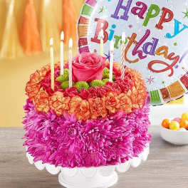 Birthday cake made of flowers with candles and a balloon