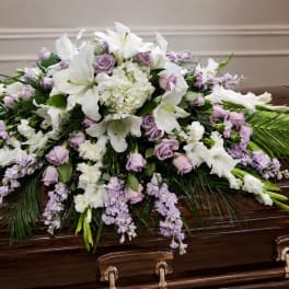 White lilies and lavender roses arranged on a casket