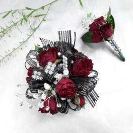 Burgundy floral boutonniere and matching wrist corsage with black ribbon accents
