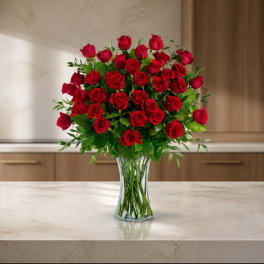Red roses arranged in a clear glass vase