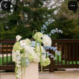 White and pale blue floral arrangement on a pedestal with a matching floor piece