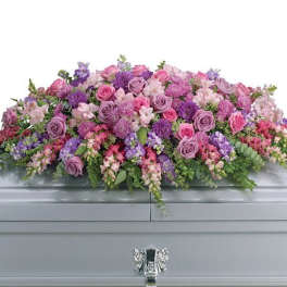 Large pink and purple floral casket spray with roses and mixed blooms