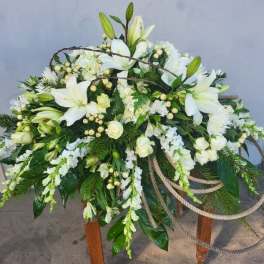 Large white floral spray with lilies and roses on a stand