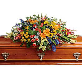 Colorful floral spray arranged on a wooden casket