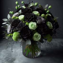 Bouquet of black and pale green roses in a clear glass vase