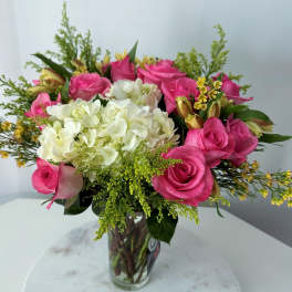 Pink roses and white hydrangeas in a clear glass vase
